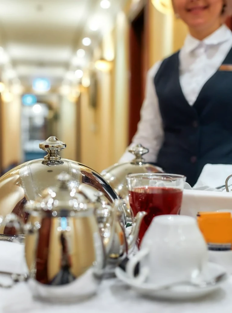 pracownik przy stoliku z napojami w hotelu